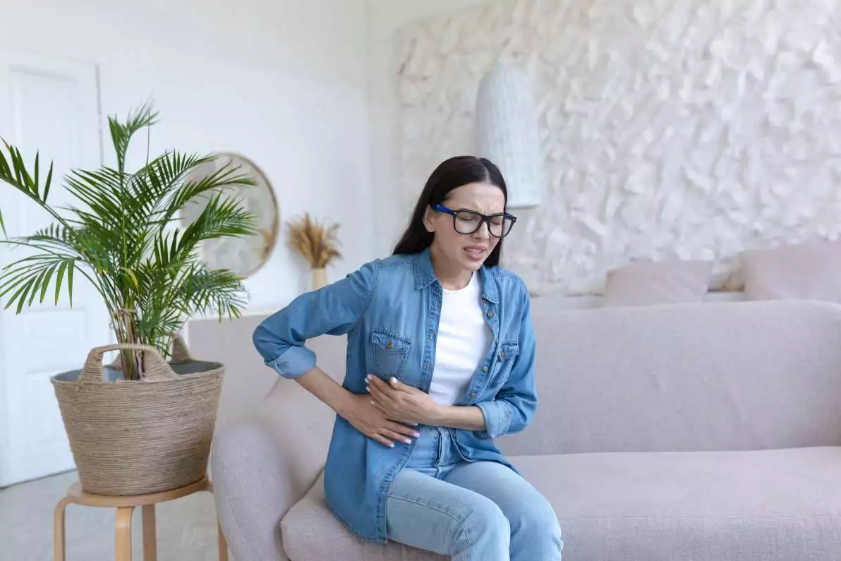 Femme assise ayant mal au foie