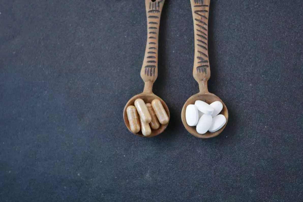Gélules et comprimés dans des cuillères en bois