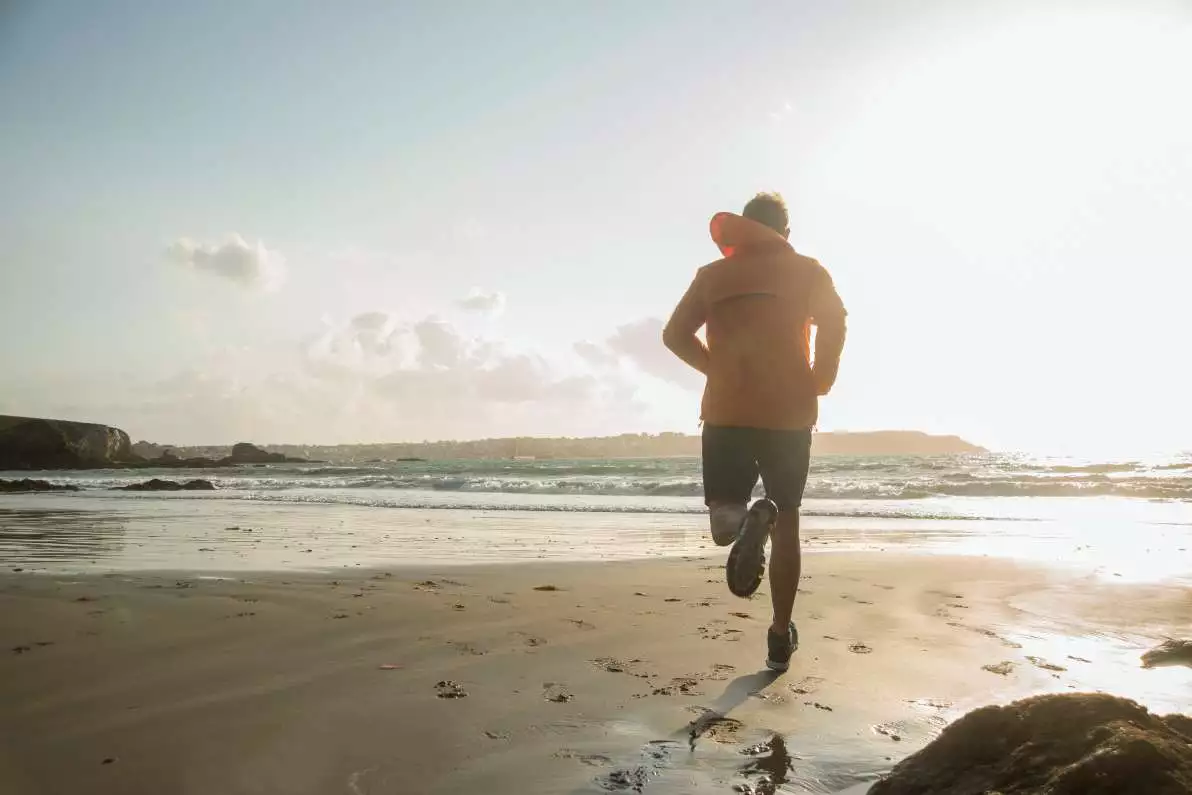 Homme courant sur la plage