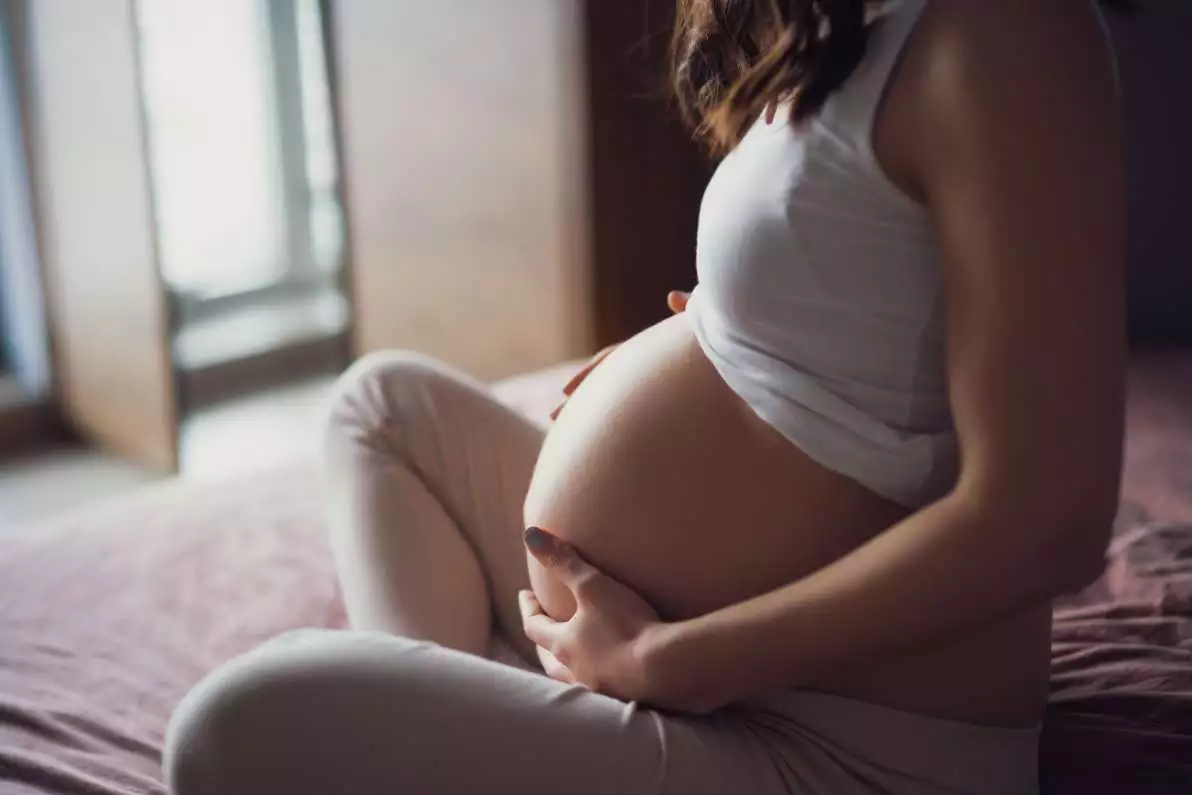Femme enceinte sur un lit