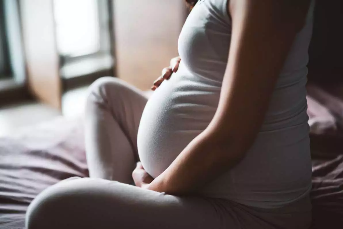 Femme enceinte sur un lit