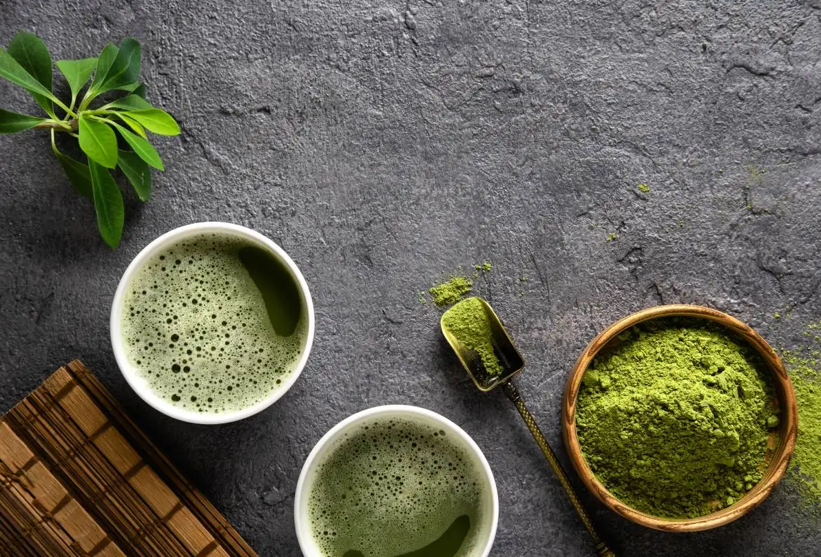 Thé matcha en poudre et accessoires pour le thé sur fond foncé