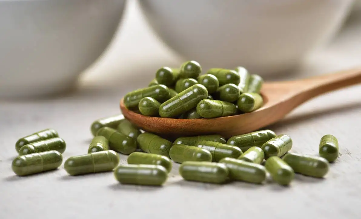Capsules de Moringa dans une cuillère en bois